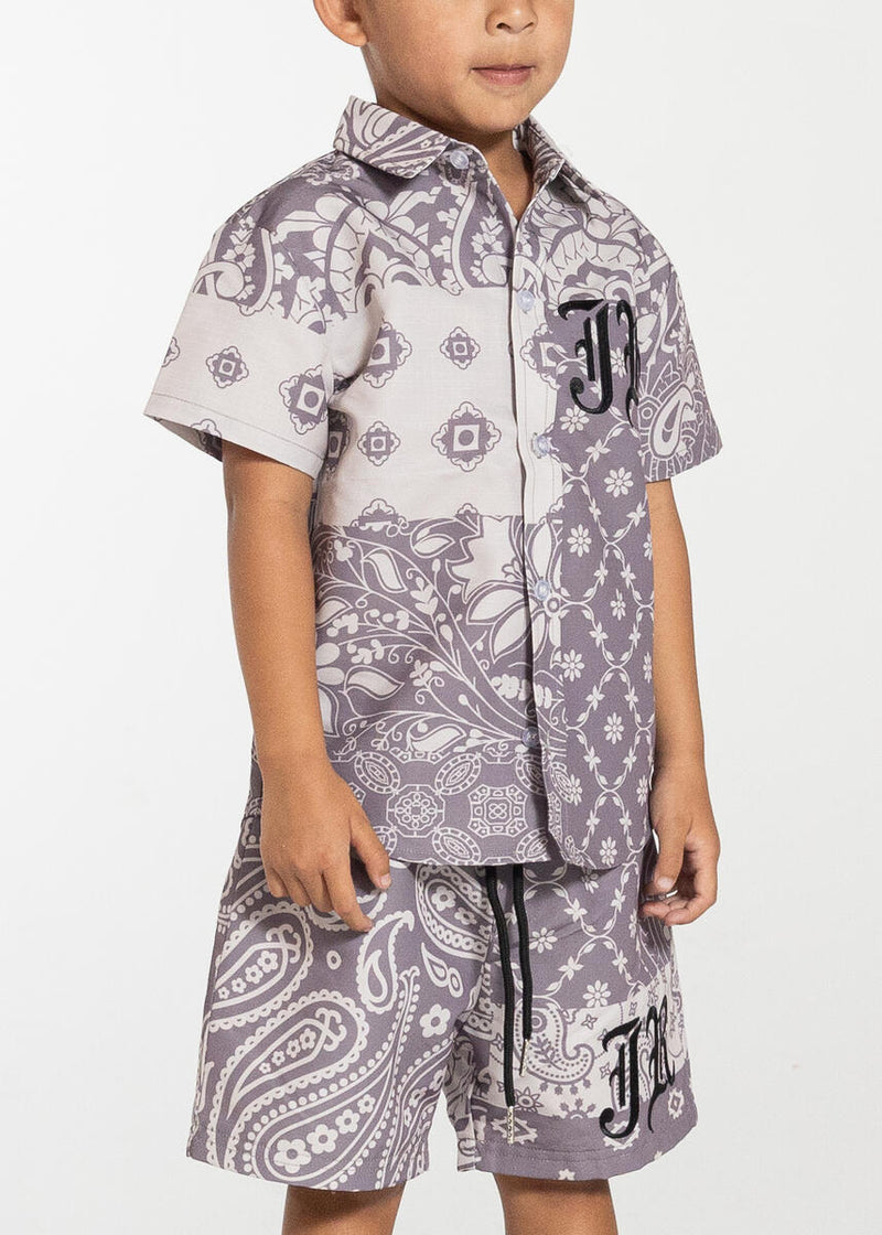 This is a boy wearing the Haus Of Jr Button up shirtAngel Button Up perfect for out in the sun and in the water  Mauve Paisley Button Up Snap Down Buttons Polyester Fabric Embroidered JR Logo Front Chest